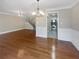 Inviting living room with hardwood floors, wainscoting, and an open layout to the kitchen and staircase at 6980 Roswell Rd # J6, Atlanta, GA 30328