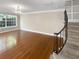 Bright living room featuring gleaming hardwood floors, a large window, and a staircase at 6980 Roswell Rd # J6, Atlanta, GA 30328