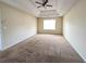 Large bedroom with a tray ceiling, ceiling fan, and neutral carpeting at 3413 Creekview Dr, Rex, GA 30273