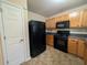 Efficient kitchen featuring wood cabinets, black appliances, and tile flooring at 3413 Creekview Dr, Rex, GA 30273