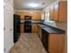 Efficient kitchen featuring wood cabinets, black appliances, and tile flooring at 3413 Creekview Dr, Rex, GA 30273
