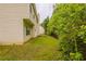 View of the backyard, showing the side of the house, lawn, and lush greenery at 4205 Post Oak Grv, Atlanta, GA 30349