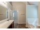 Bright bathroom featuring a soaking tub, wood-look flooring, and a spacious vanity with a large mirror at 4205 Post Oak Grv, Atlanta, GA 30349