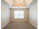 Bright empty bedroom featuring a modern chandelier, a tray ceiling and large window with natural light at 4205 Post Oak Grv, Atlanta, GA 30349