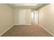 An empty bedroom with neutral walls, carpet flooring, and a bright, open doorway at 4205 Post Oak Grv, Atlanta, GA 30349