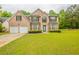 Charming two-story brick home featuring a well-manicured lawn, attached garage, and a welcoming front entrance at 4205 Post Oak Grv, Atlanta, GA 30349