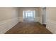 Spacious living room with wainscoting and neutral carpet, leading to a separate dining area at 4205 Post Oak Grv, Atlanta, GA 30349
