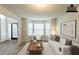 Staged living room features bay windows, neutral carpet, and white furniture at 4205 Post Oak Grv, Atlanta, GA 30349
