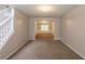 Open living room with neutral walls and carpeting, leading to a separate dining area at 4205 Post Oak Grv, Atlanta, GA 30349
