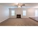 Large living room featuring carpeting, a fireplace, and plenty of natural light from the two windows at 4205 Post Oak Grv, Atlanta, GA 30349