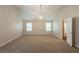 Vaulted main bedroom featuring neutral carpeting, a modern light fixture and dual windows at 4205 Post Oak Grv, Atlanta, GA 30349