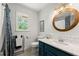 Modern bathroom featuring a blue vanity, subway tile backsplash, and a round mirror, creating a sleek and stylish space at 546 Wagon Wheel Climb, Lawrenceville, GA 30044
