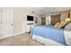 Comfortable bedroom featuring a blue bedspread, white dresser, tv and a decorative sliding barn door at 546 Wagon Wheel Climb, Lawrenceville, GA 30044