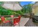 Wooden deck featuring outdoor seating with an umbrella and view of the landscaped yard and wooded area at 546 Wagon Wheel Climb, Lawrenceville, GA 30044