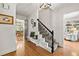 Welcoming foyer with hardwood floors, staircase with decorative iron railing, and views into dining and living areas at 546 Wagon Wheel Climb, Lawrenceville, GA 30044