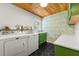 Well-appointed laundry room with a wood ceiling, green cabinets, and modern washer and dryer at 546 Wagon Wheel Climb, Lawrenceville, GA 30044