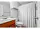 Standard full bathroom with wood vanity and shower with white curtain at 6095 Wayfarer Dr, Villa Rica, GA 30180