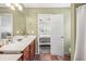 Bathroom with neutral colors, tiled floors, and a door leading to the main bedroom at 6095 Wayfarer Dr, Villa Rica, GA 30180