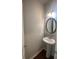 Cozy half bathroom featuring a pedestal sink, decorative mirror and tile backsplash at 236 Bobbie Way, Woodstock, GA 30189