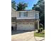 Charming townhouse showcasing a beige exterior, attached garage and well-kept front lawn at 236 Bobbie Way, Woodstock, GA 30189