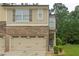Charming townhouse showcasing a beige exterior, an attached garage and well-kept front lawn at 236 Bobbie Way, Woodstock, GA 30189