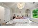 Bright main bedroom featuring a statement chandelier and large window at 236 Bobbie Way, Woodstock, GA 30189