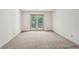 This spacious bedroom features neutral walls and carpet, as well as a glass patio door at 44 Saint Claire Ne Ln, Atlanta, GA 30324