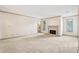 Light-filled living room featuring a fireplace, neutral carpeting, and windows with views of the outdoors at 44 Saint Claire Ne Ln, Atlanta, GA 30324