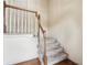 Carpeted staircase featuring white spindles and a wooden banister leading to the upper level at 44 Saint Claire Ne Ln, Atlanta, GA 30324