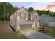 Beautiful two-story home featuring a brick facade, attached garage, landscaped front yard, and covered porch at sunset at 5003 Fairview Cir, Villa Rica, GA 30180