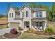 Inviting two-story brick home with a two-car garage, landscaped front yard, and a cozy covered porch at 5003 Fairview Cir, Villa Rica, GA 30180