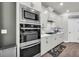 Kitchen features stainless steel oven and microwave, white cabinets and herringbone backsplash at 5003 Fairview Cir, Villa Rica, GA 30180