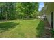 Expansive backyard with lush green grass, mature trees, and a cozy deck at 6450 Ivey Se Rd, Mableton, GA 30126