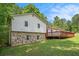 View of the back of the home, featuring stone accents, wood siding and a spacious lawn at 6450 Ivey Se Rd, Mableton, GA 30126