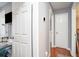 Hallway featuring neutral paint, wood-look floors, and multiple doors leading to various rooms at 6450 Ivey Se Rd, Mableton, GA 30126