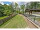 Expansive backyard featuring a manicured lawn, wood fencing, and an outdoor pavilion area at 2668 Galahad Ne Dr, Atlanta, GA 30345