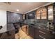 Stylish wet bar with dark cabinetry, marble countertop, and seating, creating a sophisticated entertainment space at 2668 Galahad Ne Dr, Atlanta, GA 30345