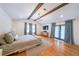 Modern main bedroom featuring hardwood floors, wood beams, and access to a private balcony at 2668 Galahad Ne Dr, Atlanta, GA 30345