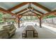 Covered outdoor seating area with a wooden table, benches, ceiling fan, and view of the backyard and pool at 2668 Galahad Ne Dr, Atlanta, GA 30345