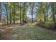 The backyard has beautiful mature trees and landscaping surrounding a house with an attached screened in porch at 45 Park Place Dr, Covington, GA 30016