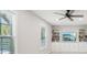 Bright living room with large windows, a ceiling fan and built-in cabinets and bookshelves at 45 Park Place Dr, Covington, GA 30016