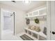 Mud room with a white bench, hooks, storage, and a built in cubbies with sliding door at 45 Park Place Dr, Covington, GA 30016