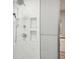 Modern shower stall featuring white marble tile and built in shelving at 45 Park Place Dr, Covington, GA 30016
