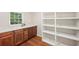 Spacious storage area with wood floors and open white shelving and cabinets at 45 Park Place Dr, Covington, GA 30016