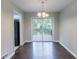 Sunlit dining area featuring dark wood floors, contemporary light fixture, and sliding doors to outdoor deck at 5340 The Savoy St, Atlanta, GA 30349