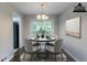 Staged dining room featuring a round table with seating for four near the backyard sliding glass doors at 5340 The Savoy St, Atlanta, GA 30349