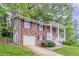 Two-story brick home with white trim, covered front porch, and attached garage at 5340 The Savoy St, Atlanta, GA 30349