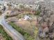 Aerial view showing the neighborhood, the home's pool and horse areas, and mature trees at 401 Nichols Dr, Suwanee, GA 30024