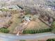 Expansive aerial view showcasing the home's setting on a large lot, complete with horse paddock, mature trees, and lush surroundings at 401 Nichols Dr, Suwanee, GA 30024