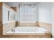 Large tub with tile surround and a sunny window at 401 Nichols Dr, Suwanee, GA 30024